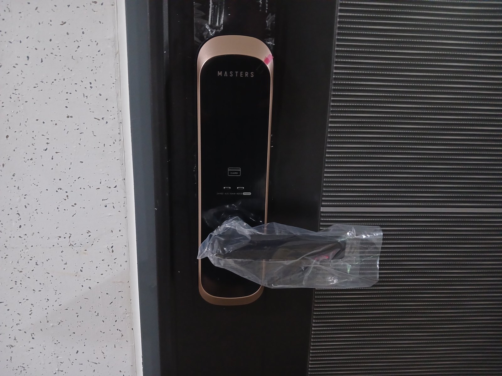 원미구 역곡1동 출장 — 짙은 문에 단 구리빛 테 레버형 도어락, 가운데 카드 표시와 투명 비닐을 감은 레버